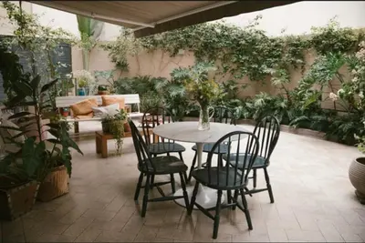 a patio with a table and chairs and plants at Huaca Pucllana Design Apartment between Miraflores and San Isidro in Lima