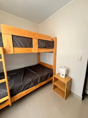 a room with two bunk beds and a desk at Casa privada y acogedora en Ica con Parking in Ica