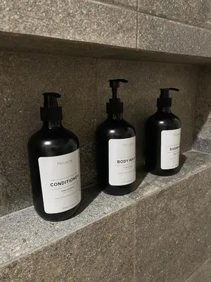 three bottles of soap sitting on a stone shelf at Steinhaus - Nature, calm and comfort in Oxapampa