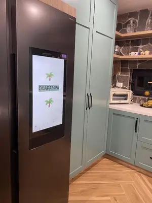 a kitchen with a screen on the door of a refrigerator at Steinhaus - Nature, calm and comfort in Oxapampa