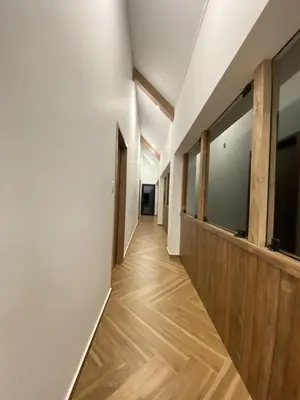 a hallway with white walls and wood floors and a door at Steinhaus - Nature, calm and comfort in Oxapampa