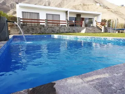 a swimming pool with a fountain in front of a house at Casa de campo Cieneguilla Vista Bonita in Cieneguilla