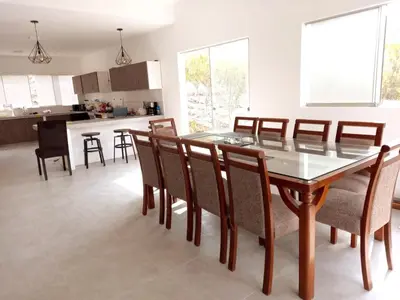 a dining room and kitchen with a glass table and chairs at Casa de campo Cieneguilla Vista Bonita in Cieneguilla