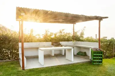 a pavilion with a white table and a bench at Casa de campo Cieneguilla Vista Bonita in Cieneguilla