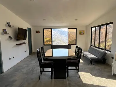 a dining room with a table and chairs and a couch at House with a panoramic view of the city and mountains in San Miguel