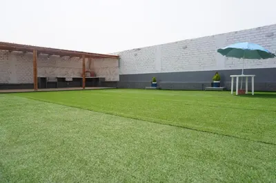 a large lawn with an umbrella in a building at Departamento cerca a la playa 202 in Punta Negra