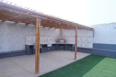 a large white brick building with a pavilion at Departamento cerca a la playa 202 in Punta Negra