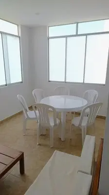 a white table and chairs in a room with windows at Departamento cerca a la playa 202 in Punta Negra