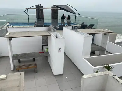 a balcony of a building with a view of the ocean at Life is better by the sea in Lima