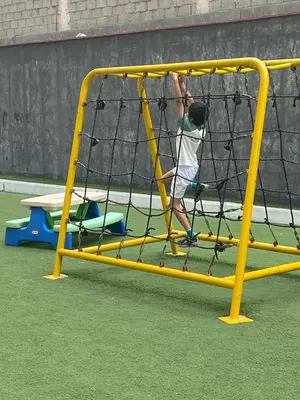 a man playing in a batting cage in a playground at Life is better by the sea in Lima
