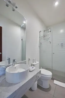 a white bathroom with a sink and a toilet at Barranco Bright apartment with Balcony in Lima