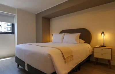 a bedroom with a large bed and a lamp on a night stand at Marvelous 2BR with Balcony in Miraflores in Lima
