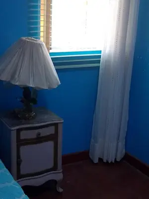 a blue room with a table with a lamp on it at San Juan in Lima