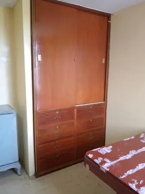a large wooden cabinet in a room with a bed at San Juan in Lima