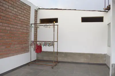 a clothes rack in a room next to a brick wall at Casa de Campo Pachacamac in Pachacamac
