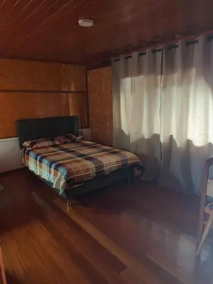 a bed sitting in a room with a window at Oxapampa Center Room- habitacion centro in Oxapampa