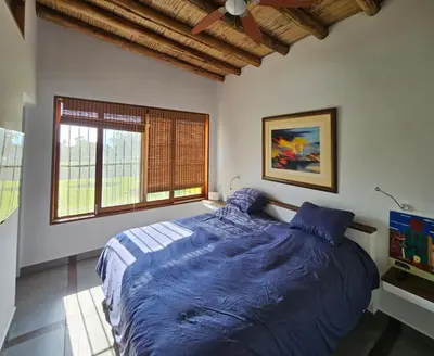 a bedroom with a large bed with blue sheets at Spacious 4BR Country House with Pool in Mala in Asia