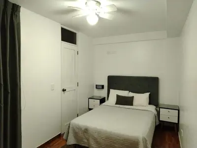 a bedroom with a bed and a ceiling fan at Hostal Mirador in Pisco