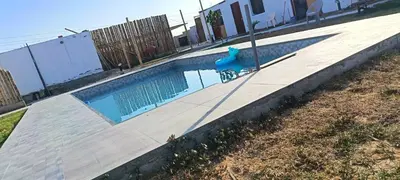 a swimming pool with a blue chair next to it at Descanso del Guerrero - PARACAS in Paracas