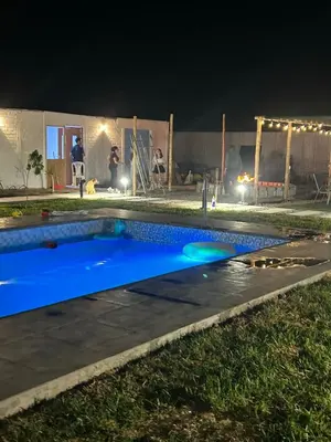 a swimming pool at night with people in the background at Descanso del Guerrero - PARACAS in Paracas