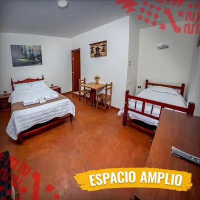 a bedroom with two beds and a table in it at La Finca de la Norteñita 1926 in Santa Rosa de Quives