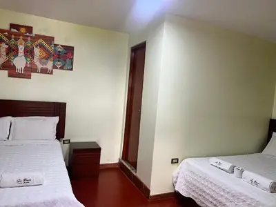 a hotel room with two beds and a window at La Finca de la Norteñita 1926 in Santa Rosa de Quives