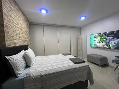 a bedroom with a bed and a tv on the wall at Albano Penthouse íntimo piscina y vista al mar in Lima