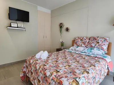 a bedroom with a bed and a tv on the wall at Condominio Ocean Reef Playa Norte San Bartolo in San Bartolo