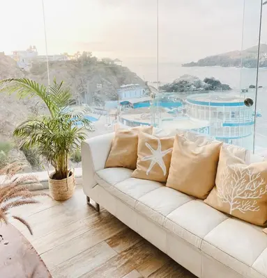 a white couch in a room with a large window at Infinitive view San Bartolo in San Bartolo