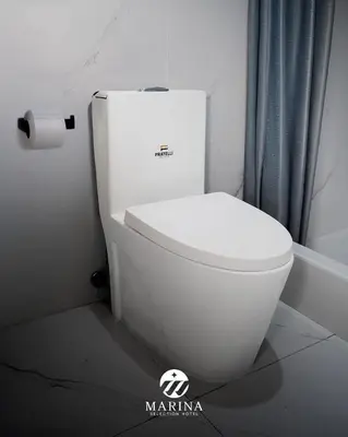 a white toilet in a bathroom with a roll of toilet paper at Marina Selection Hotel in San Juan de Marcona