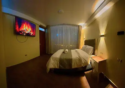 a bedroom with a bed and a tv on the wall at MAR y LAGO EXPERIENCE in Lunahuaná
