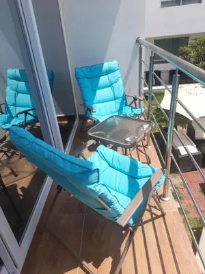 a pair of chairs and a table on a balcony at MAR y LAGO EXPERIENCE in Lunahuaná
