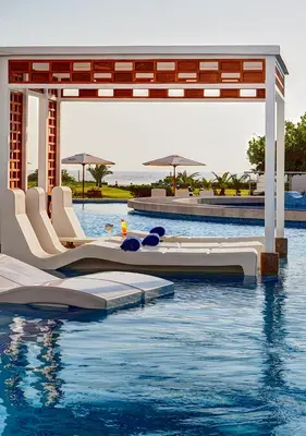 a pool at a resort with chairs and water at VPX Hotel in Asia
