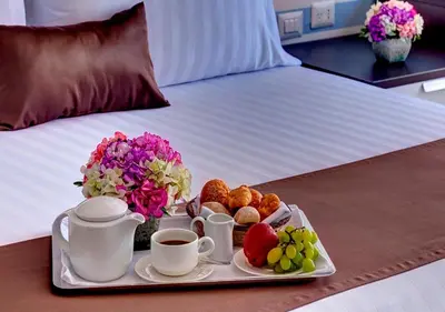a tray of food and coffee on a bed at VPX Hotel in Asia