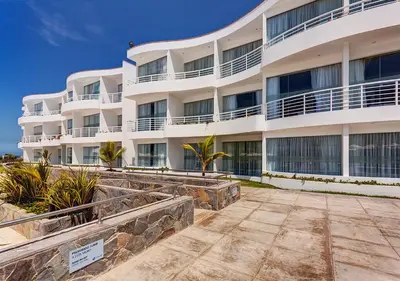 a large white building with palm trees in front of it at VPX Hotel in Asia