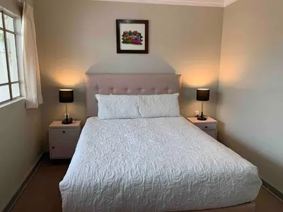 a bedroom with a large white bed with two lamps at Full Mini Apartment for 2 in Cusco