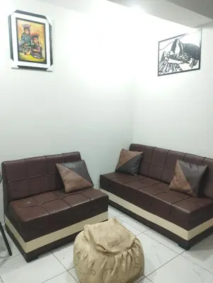 a living room with two brown couches and a ottoman at Residencia PAZ Y BIEN in Cusco