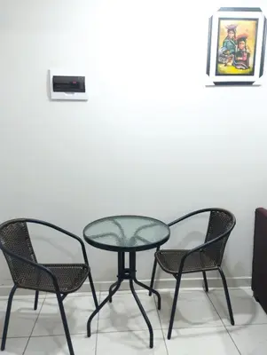 a glass table and two chairs in a room at Residencia PAZ Y BIEN in Cusco