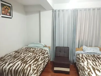 a room with two beds and a chair in it at Residencia PAZ Y BIEN in Cusco