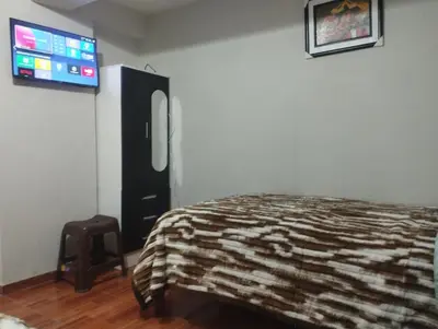 a bedroom with a bed and a flat screen tv at Residencia PAZ Y BIEN in Cusco