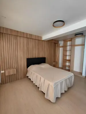 a bedroom with a bed with a wooden wall at Matrix Alojamiento in Punta Negra