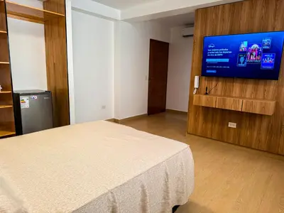 a bedroom with a bed and a flat screen tv at Matrix Alojamiento in Punta Negra