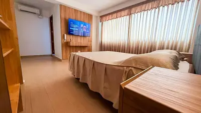 a bedroom with a bed and a flat screen tv at Matrix Alojamiento in Punta Negra
