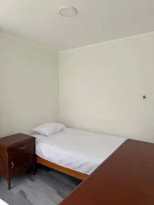 a small bedroom with a bed and a nightstand at San Borja Room Baño Compartido in Lima
