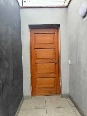 a wooden door in a room with a wall at San Borja Room Baño Compartido in Lima
