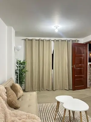 a living room with a couch and a table at Departamento de un solo ambiente in Lima