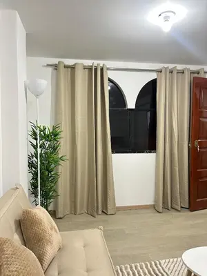 a living room with a couch and a window at Departamento de un solo ambiente in Lima