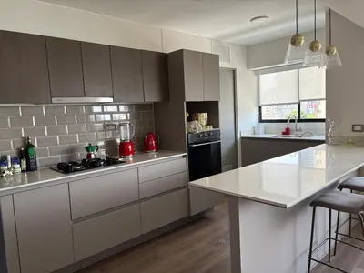 a kitchen with white cabinets and a counter top at Beautiful brand new apartment for rent in Lima