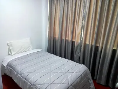 a bed sitting next to a window with curtains at Departamento 3 dormitorios 4A in Lima