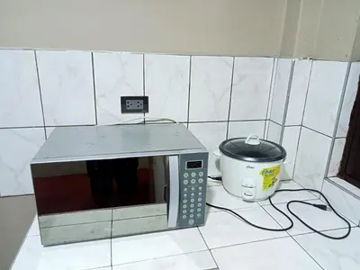 a microwave sitting on a counter next to a slow cooker at Departamento 3 dormitorios 4A in Lima